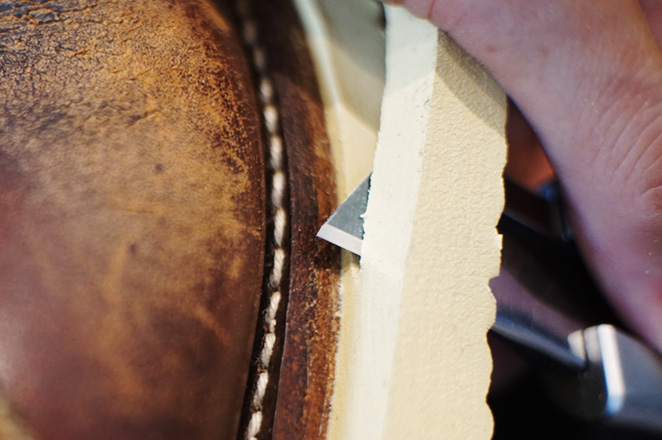 靴底の余分な箇所をカッターで切り回すアイリッシュセッターの靴修理の作業